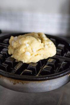 a waffle with some food on top of it in a frying pan, ready to be cooked