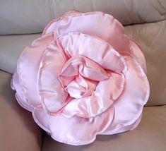 a pink flower sitting on top of a couch