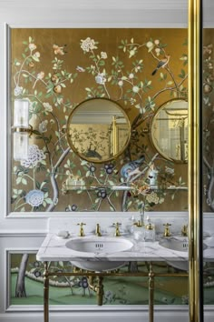 a bathroom with two sinks and mirrors on the wall next to each other in front of a mirror