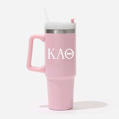 a pink travel mug with the word kao on it and a straw sticking out