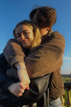 two people hugging each other on a sunny day