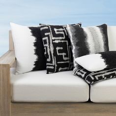 black and white pillows sitting on top of a couch