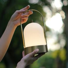 a person holding a lamp in their hand with the light on it's side