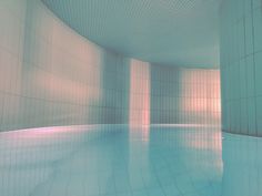 an empty swimming pool with tiled walls and floor, in the middle of a room