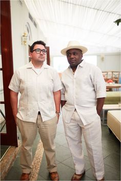 two men standing next to each other wearing white clothing