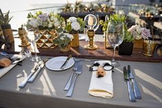 the table is set with silverware and flowers