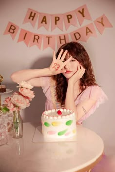 a woman sitting at a table with a birthday cake in front of her and the words happy birthday written on it