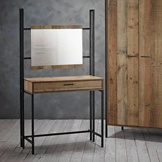 a wooden table with a mirror on it next to a cabinet and door in a room