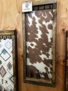 two framed cow hides on display in a wood frame