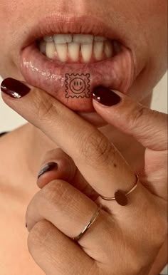 a woman is holding her tongue out with a smiley face on it