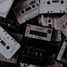 a pile of old and used cassettes sitting on top of each other in black and white