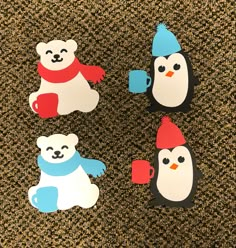 four penguin and polar bear magnets sitting on top of a carpeted floor next to each other