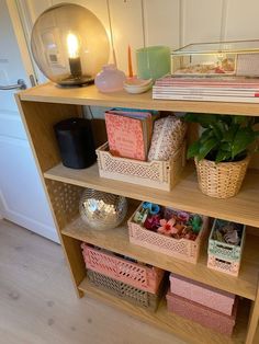 a book shelf filled with lots of books next to a vase and potted plant