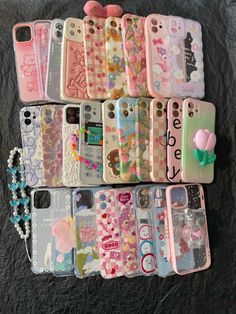 there are many cell phones lined up on the bed with beads and charms attached to them