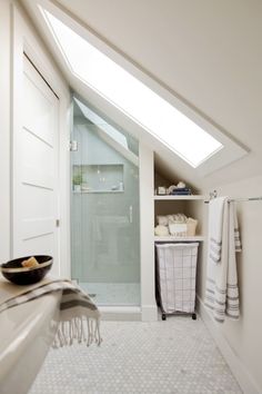 an attic bathroom with skylight and shower