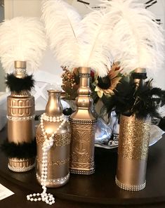 decorative vases with feathers and pearls on a table