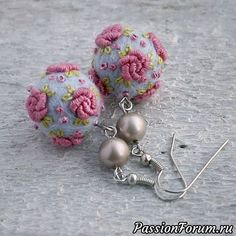 two balls with flowers on them are sitting next to each other and dangling from hooks