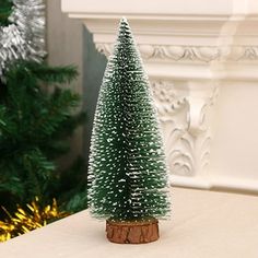 a small green christmas tree sitting on top of a table