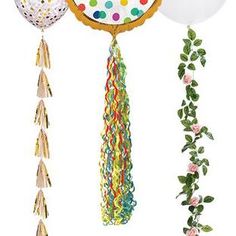 balloons and streamers hanging from the ceiling in front of a white backdrop with confetti