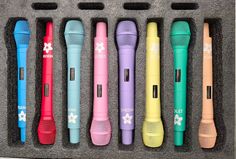 six different colored microphones lined up in a box