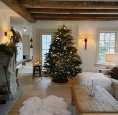 a living room filled with furniture and a christmas tree in the middle of the room