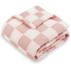 the pink and white checkered blanket is folded up on top of each other,