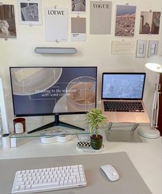 a desk with a laptop, keyboard and monitor on it next to a plant in a pot