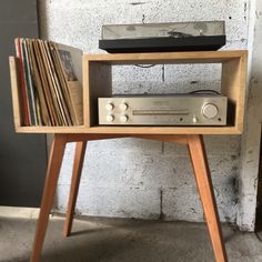 an old stereo player sitting on top of a wooden stand