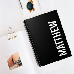 an open notebook sitting on top of a table next to a pair of scissors and other office supplies