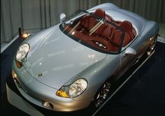 a silver sports car parked in front of a metal building with red seats on it