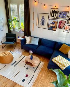 a living room with blue couches and pictures on the wall above it's coffee table