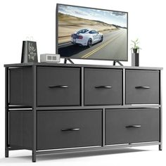 an entertainment center with drawers and a flat screen tv mounted on the wall above it