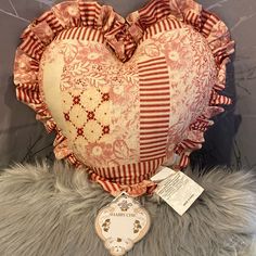 a heart shaped pillow sitting on top of a fur covered floor next to a tag