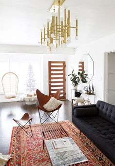 a living room filled with furniture and a chandelier hanging over the top of it