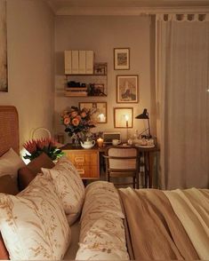 a bed sitting in a bedroom next to a desk with a lamp on top of it