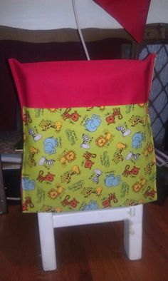 a child's chair with a red and yellow pillow on it