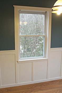 the height of a window in a room with blue walls and white trim on it