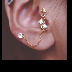 an ear piercing with stars and chains attached to it