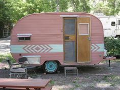 an old trailer is parked next to a picnic table