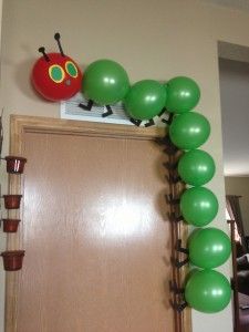 the very hungry caterpillar is on top of the balloon arch in the hallway