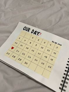 a calendar with the word our day written on it sitting on a sheet of paper