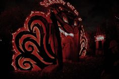 a lit up sign with a dragon on it's face and lights around it