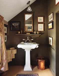 a white pedestal sink sitting under a bathroom mirror