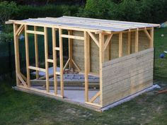 a wooden shed is being built in the yard