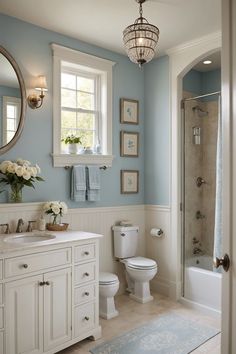 a bathroom with blue walls and white cabinets is pictured in this image, it has a chandelier over the toilet