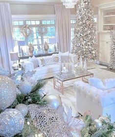 a living room filled with white furniture and christmas decorations