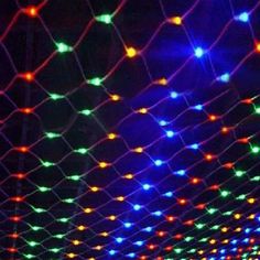 colorful lights are hanging from the ceiling in an indoor area that is lit up at night