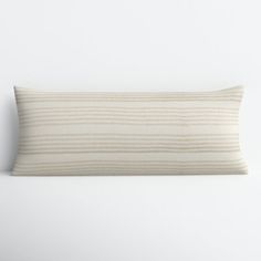 a striped pillow on a white wall