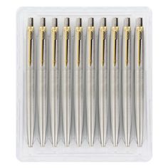 six metal ballpoint pens in a clear plastic case on a white background with clippings