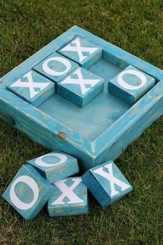 a blue box with white letters on it sitting in the grass next to some blocks